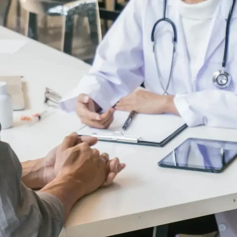 Ärztin im Gespräch mit einem Patienten in der Praxis