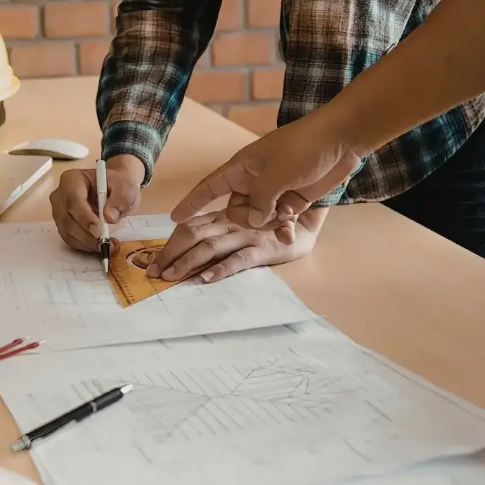 Bauunternehmer besprechen einen Bauplan am Schreibtisch
