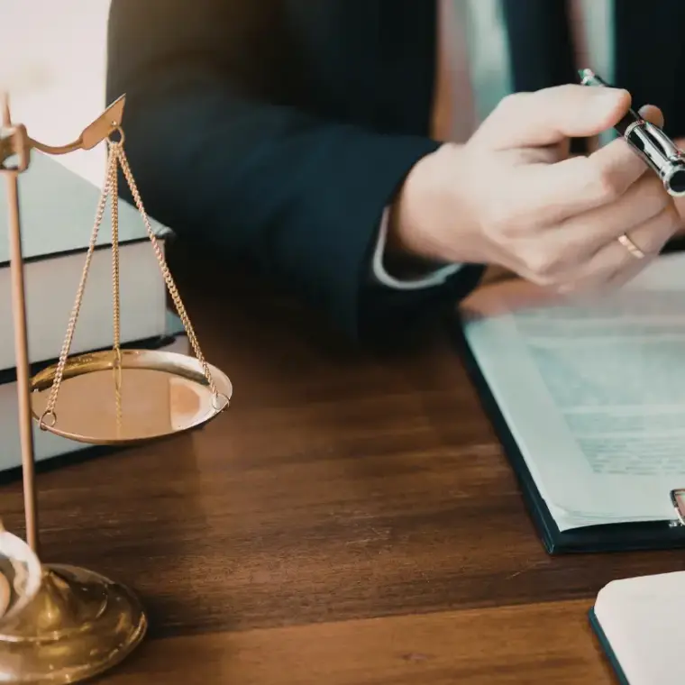 Rechtsanwalt am Schreibtisch mit Waage der Justitia und Akten